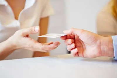 person handing a card to another person